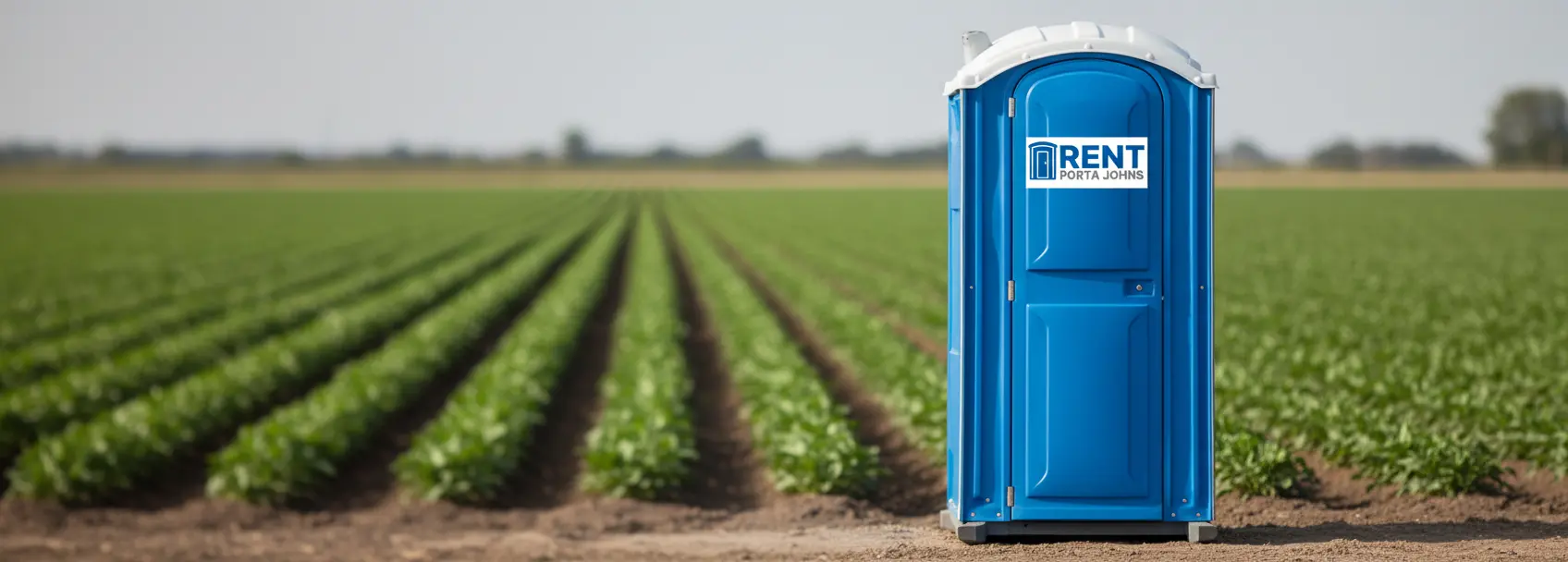 Blue portable restroom with Rent Porta Johns logo placed beside an agricultural crop field